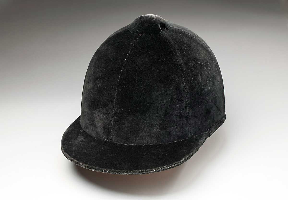 A black velvet horse riding helmet worn by Emilie Roach (front and back view). - click to view larger image