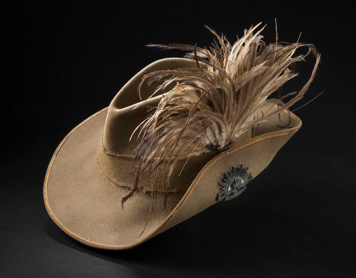Slouch hat with the proper left side of the brim turned up and decorated with emu feathers. There is a pin on the turned up side that reads 'AUSTRALIAN / COMMONWEALTH / MILITARY FORCES'. - click to view larger image