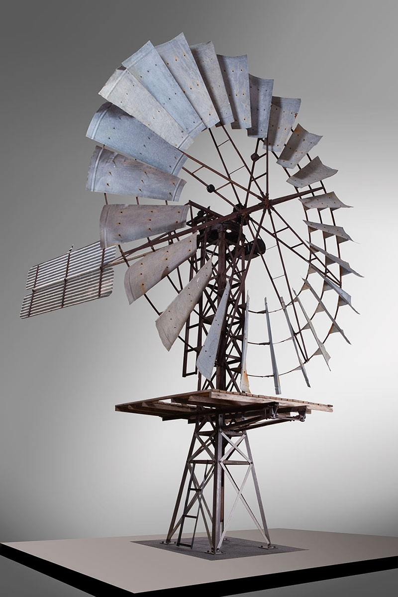 A photo of the top section of a windmill on display indoors. - click to view larger image