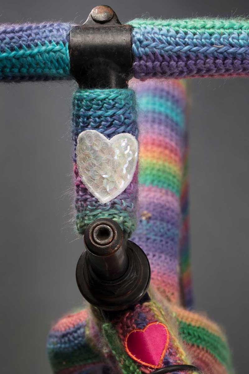 Bike handlebars covered in rainbow-coloured wool. - click to view larger image