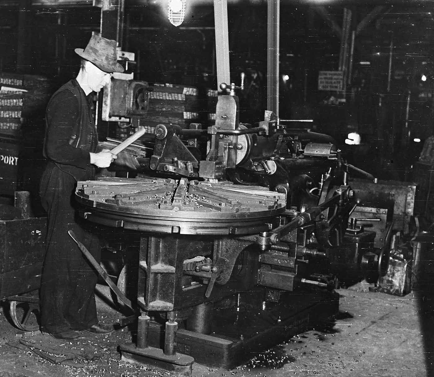 Black and white photo of a man working in a factory.