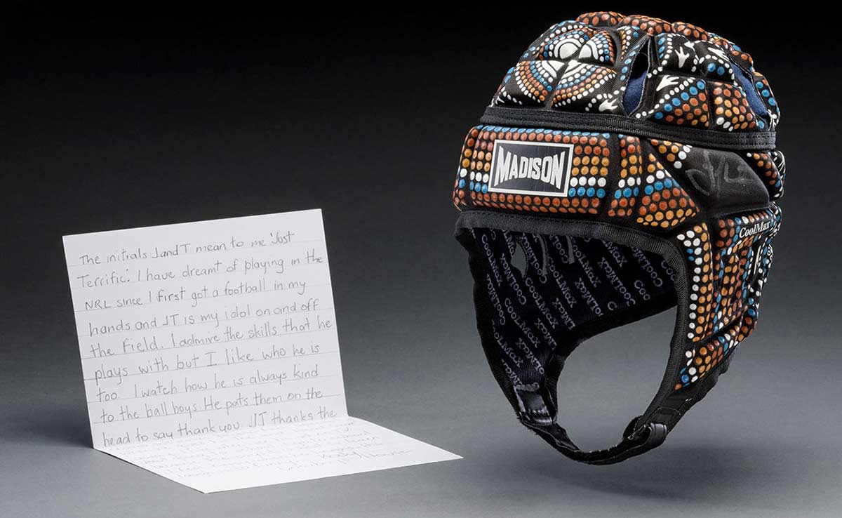 A black fabric helmet with 'MADISON' printed in white letters on the front. The helmet is decorated with dots and animal prints in blue, red, orange and white. - click to view larger image
