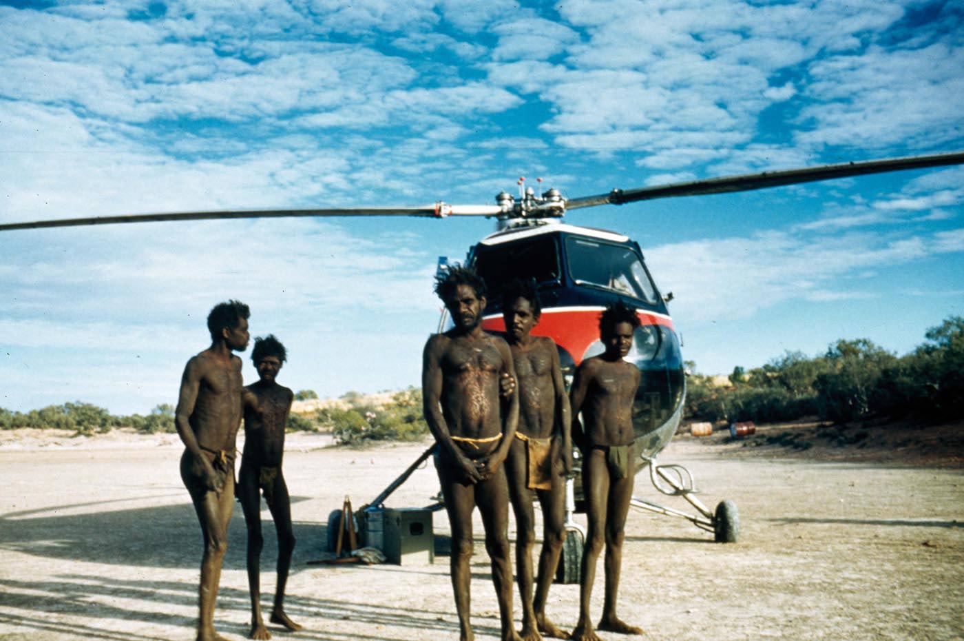 Men standing in front of a helicopter.