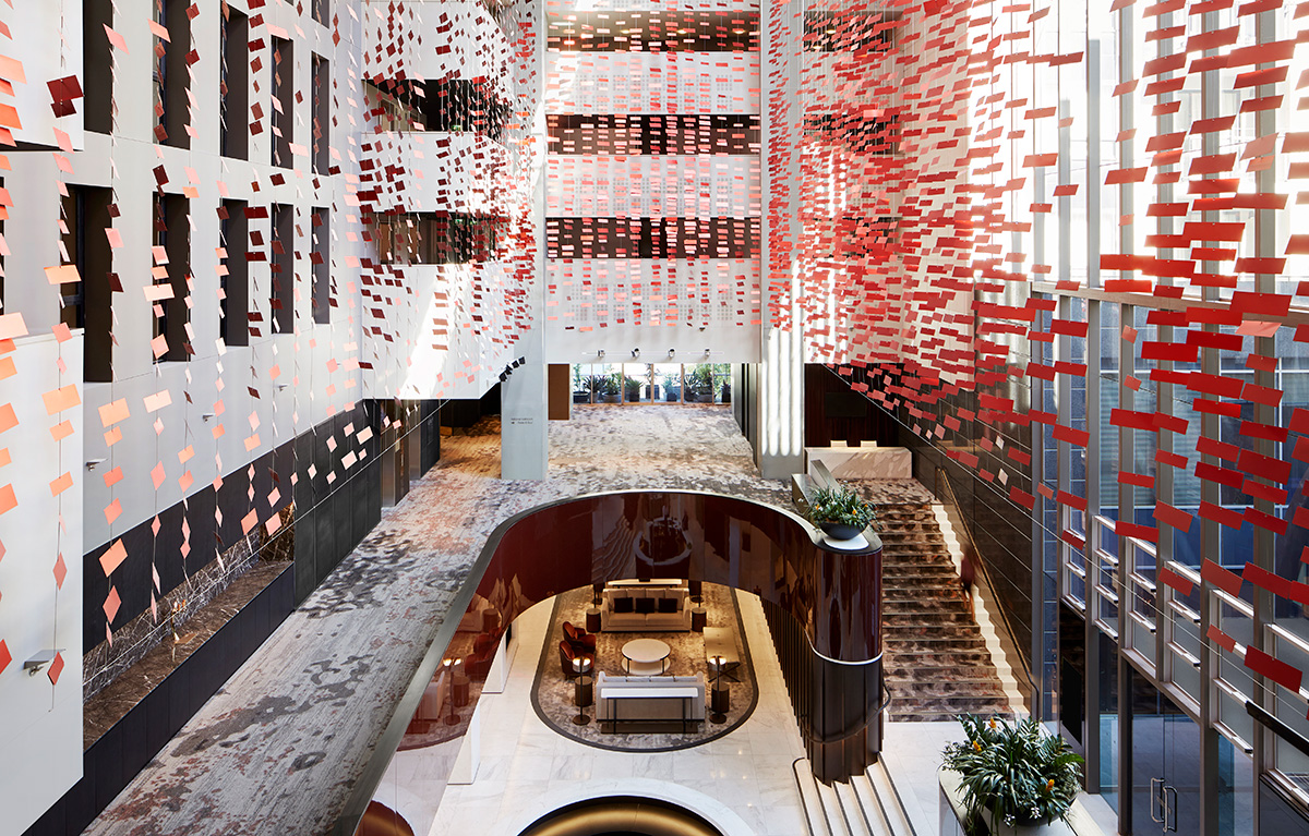 Inside of a hotel atrium with several levels of rooms extending above. 