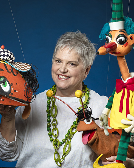 A photograph of Rebecca Hetherington with Mr Squiggle, Bill Steamshovel and Gus puppets.