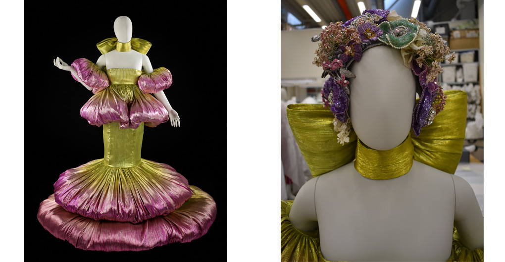 Yellow and pink gown placed onto a standing, full length mannequin. The strapless yellow bandeau balloons into tubular, puffed arm bands; and two pink puffs dropping at the waist. The yellow bandau is cinched at the waist and moves down into a long, narrow  yellow skirt, which balloons out below the knees in two large, concentric, circular pink puffs. Around the throat is a large yellow bow, tied at the back.   The dress draws its inspiration from flowers, notably the blooming petals of a peony. The silhouette of the dress resembles a flower in bloom.