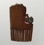 Comb made of dark brown wood, embellished with a greenish opalescent piece of shell.