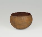 Drinking bowl made from a light-brown young coconut where the shell was split open just above its widest point.