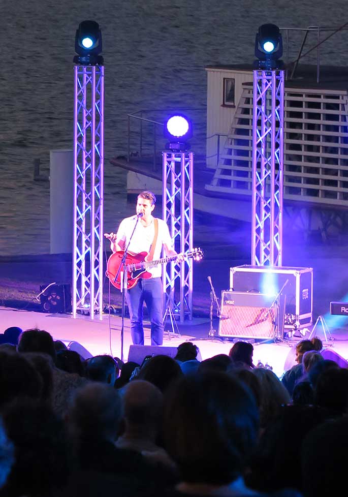 A man on a brightly-lit stage.