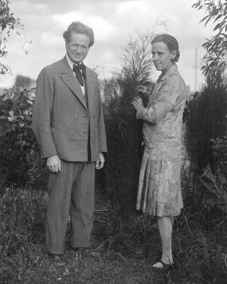 An old black and white photo of a middle-aged couple outdoors. - click to view larger image