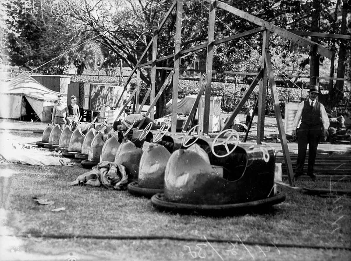A row of dodgem cars. Two men and two children are visible in the photo. - click to view larger image