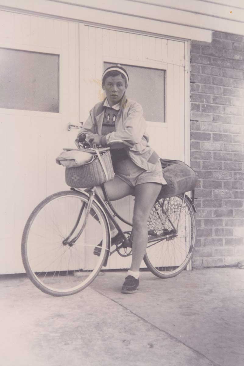 Black and white photograph of Reima Miezitis sitting her bike. - click to view larger image