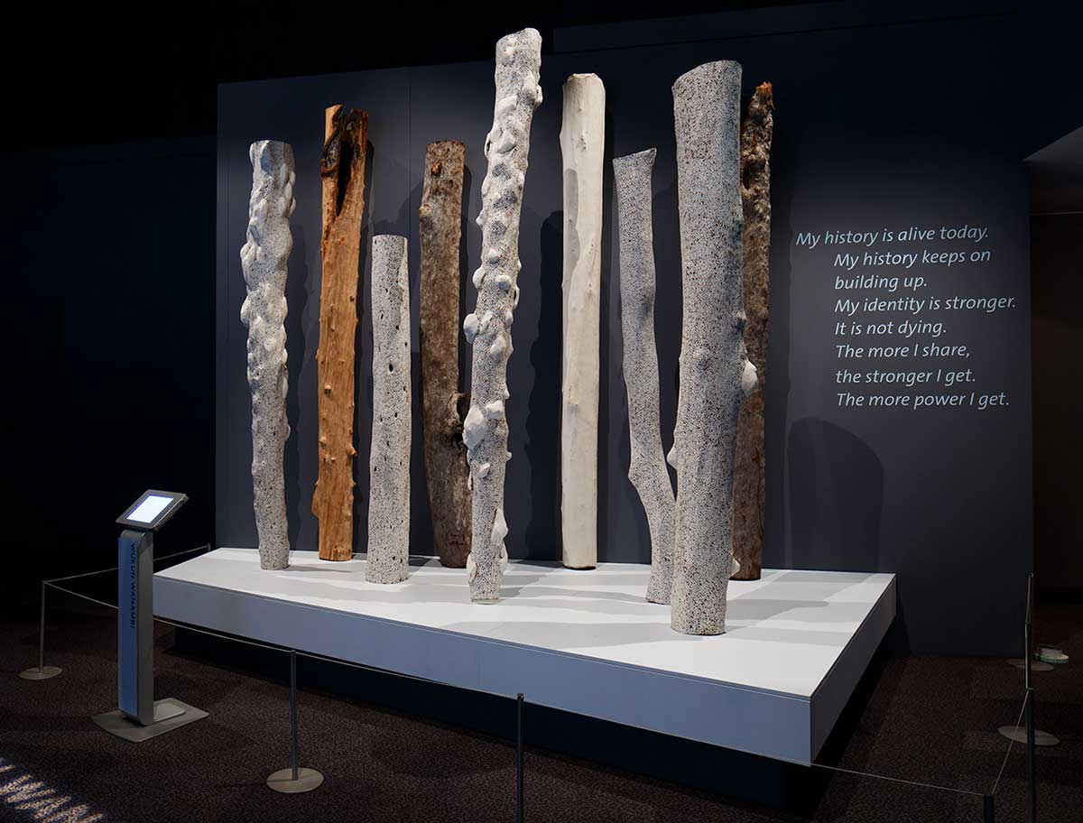 Series of long cylindrical sculptures in a gallery display.