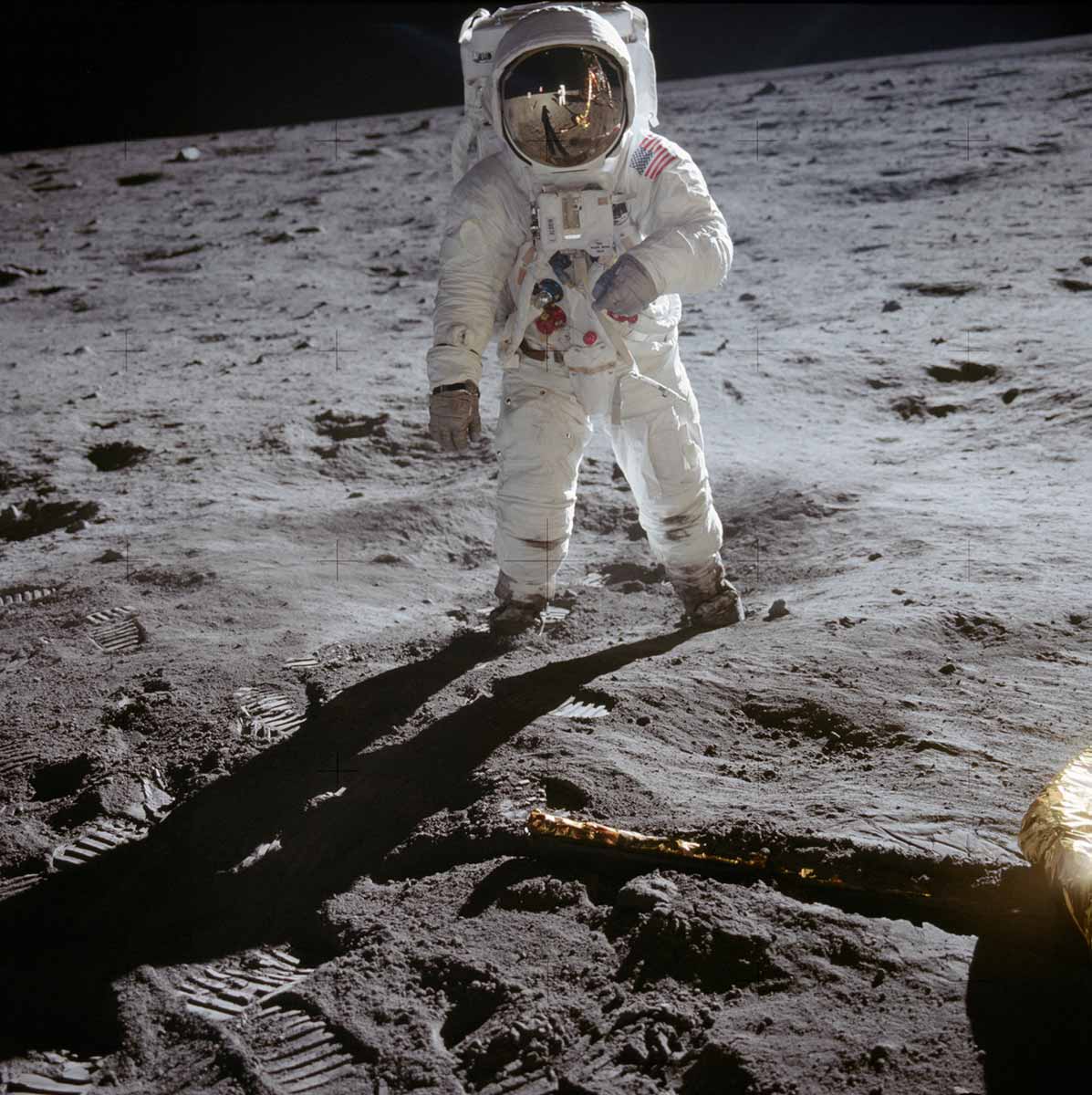 A photograph of a person, dressed in full astronaut gear, is standing on the Moon's landscape and is facing the camera. - click to view larger image