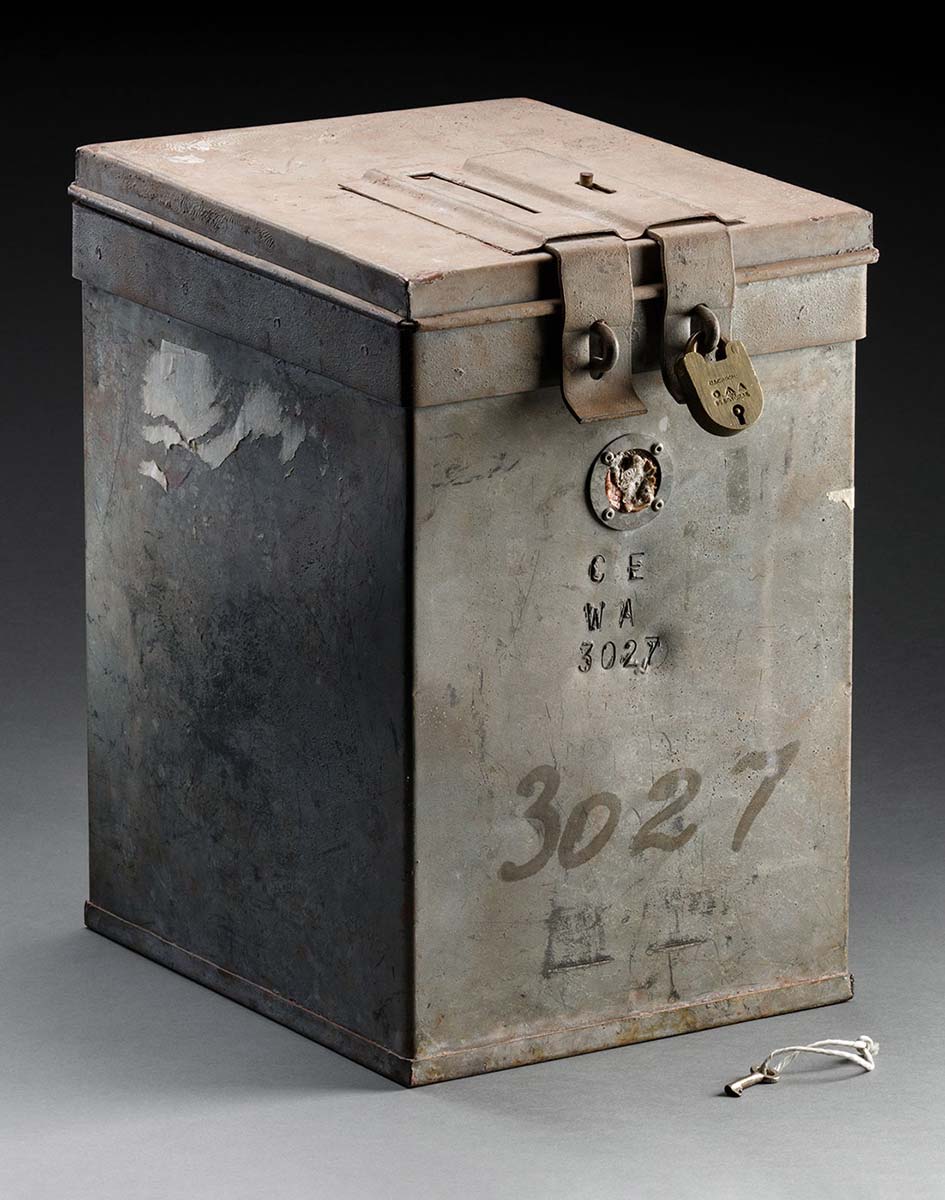 A rectangular, galvanised metal voting box with a hinged lid. The text 'CE WA 3027' is on the front of the box and the number '3027' is repeated in black marker. - click to view larger image