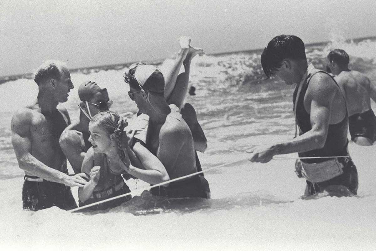 Lifesavers rescuing a young girl struggling in the surf at Kirra, Queensland in 1948.