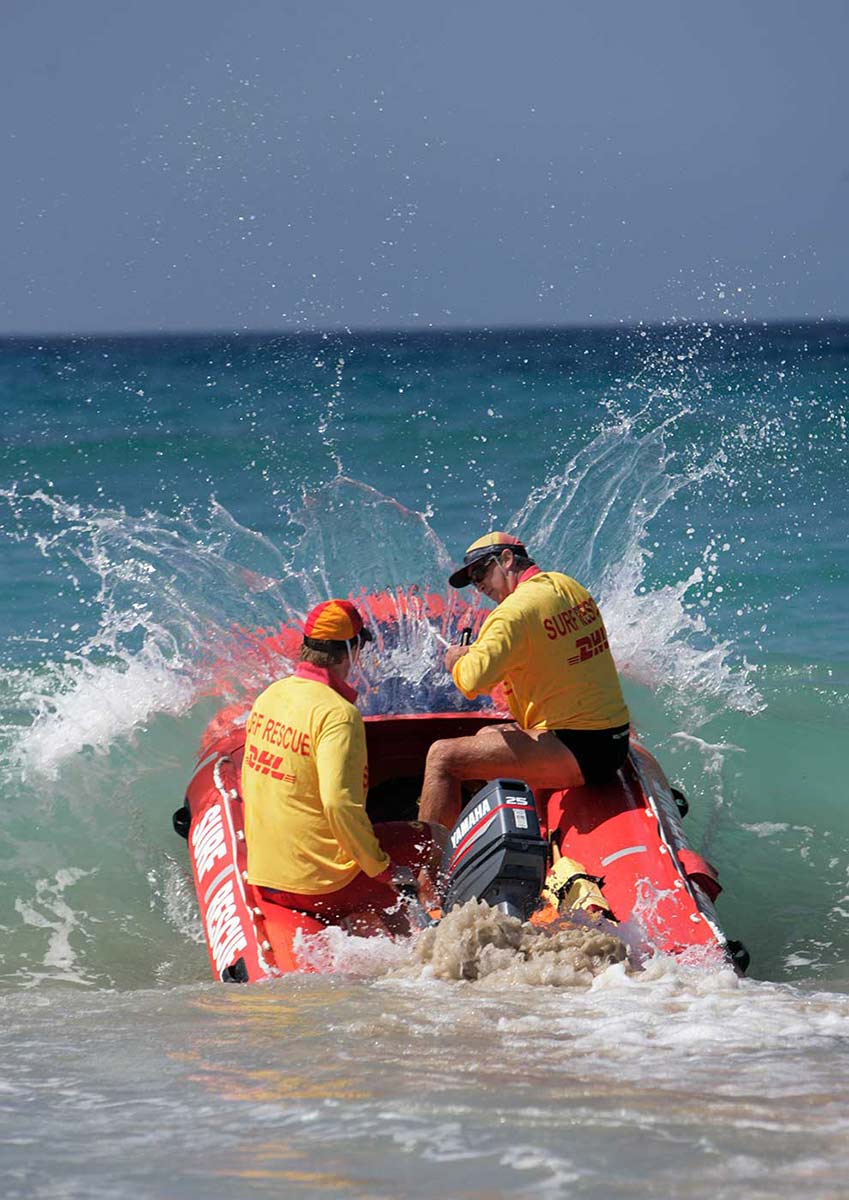 Two lifesavers in the surf in an inflatable rescue boat. - click to view larger image