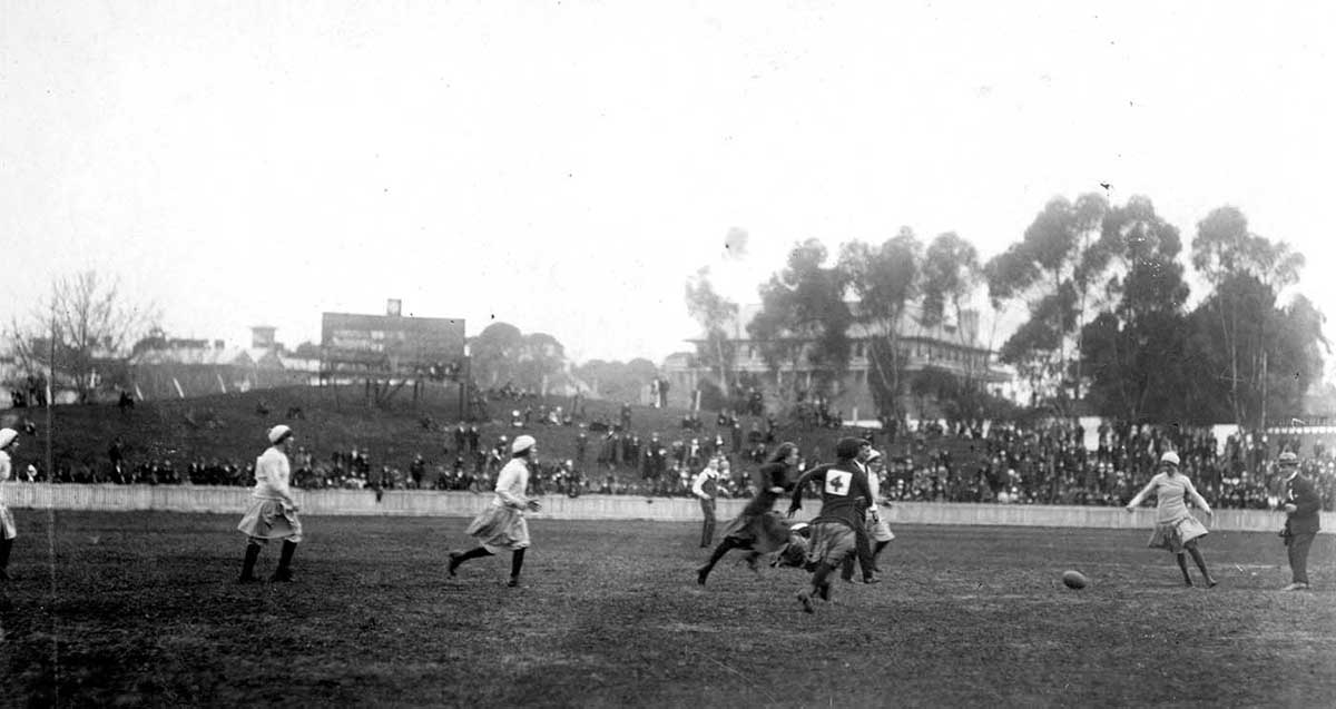 An old black and white photograph featuring women playing football in 1918.