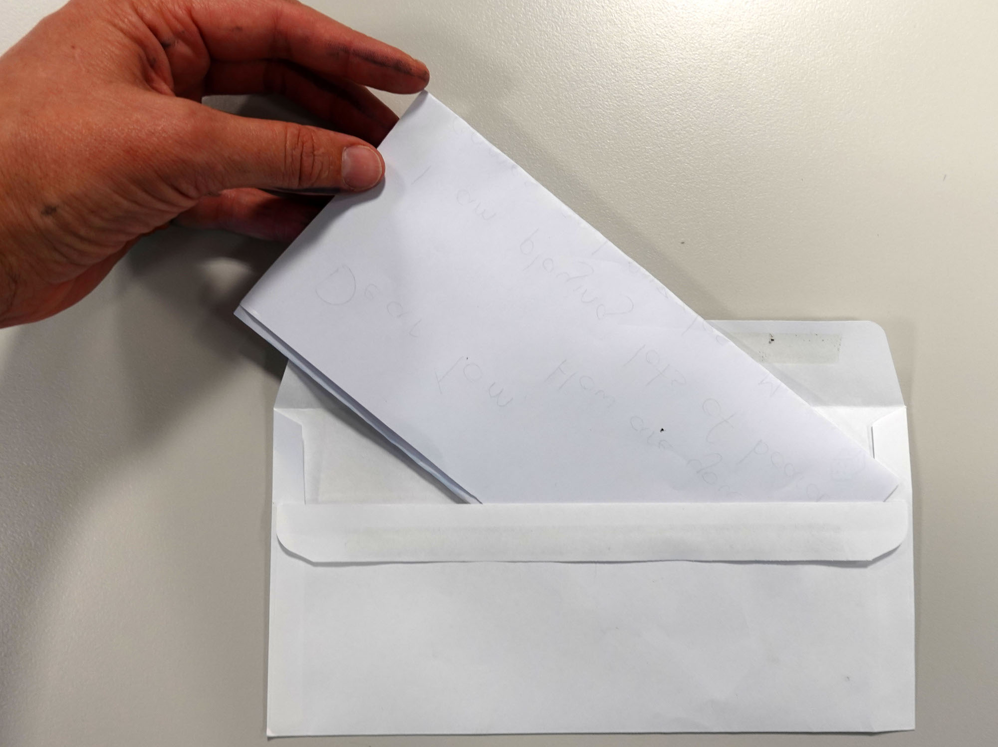 A letter being inserted into an envelope