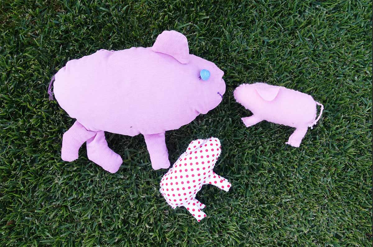 A display of three hand made pigs.