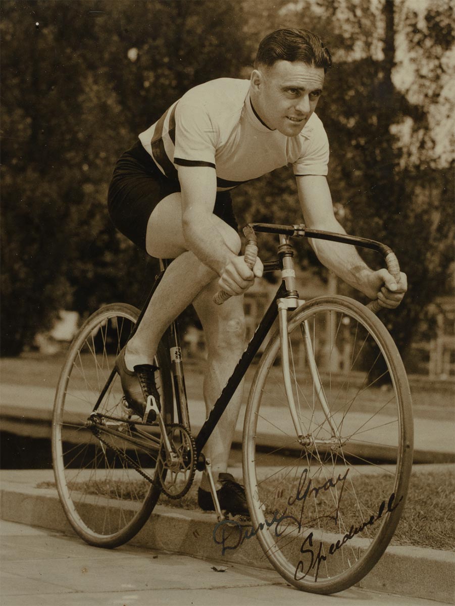 Black and white photograph of a man cycling. - click to view larger image
