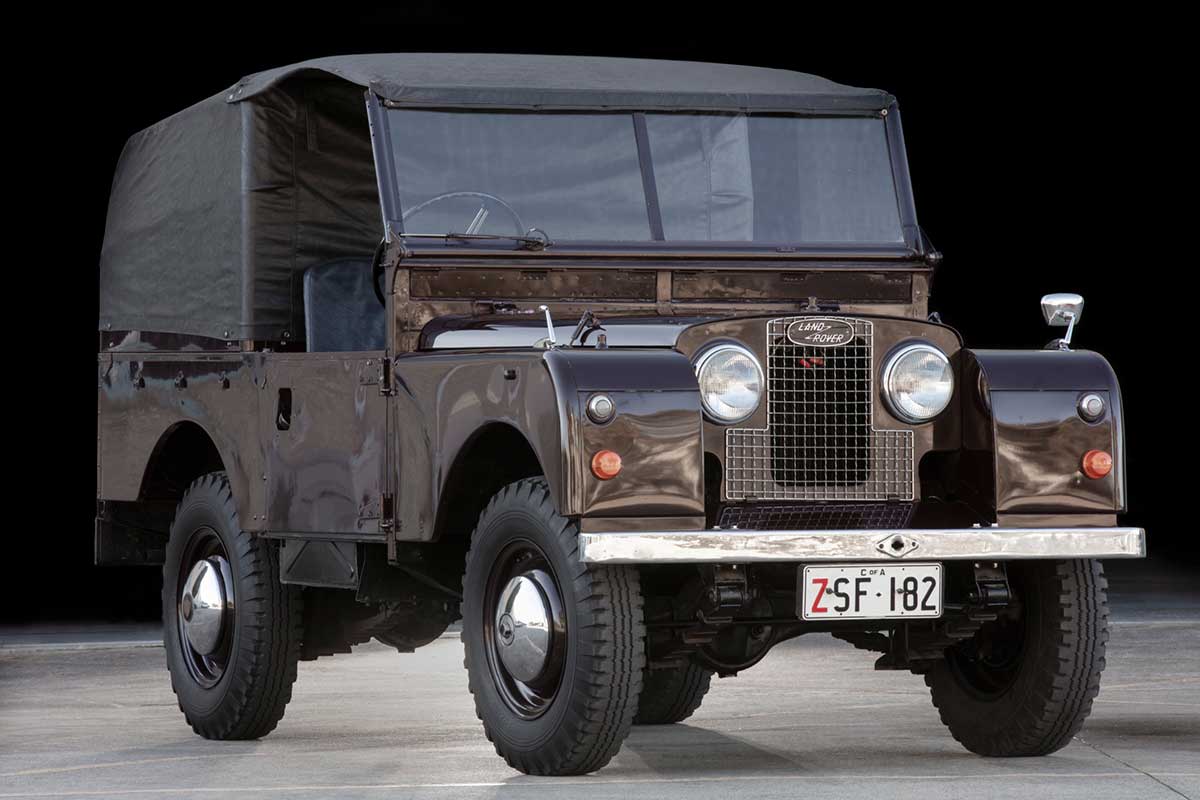 Dark-coloured Land Rover ute with detachable roof cover in place, on show in a gallery. - click to view larger image