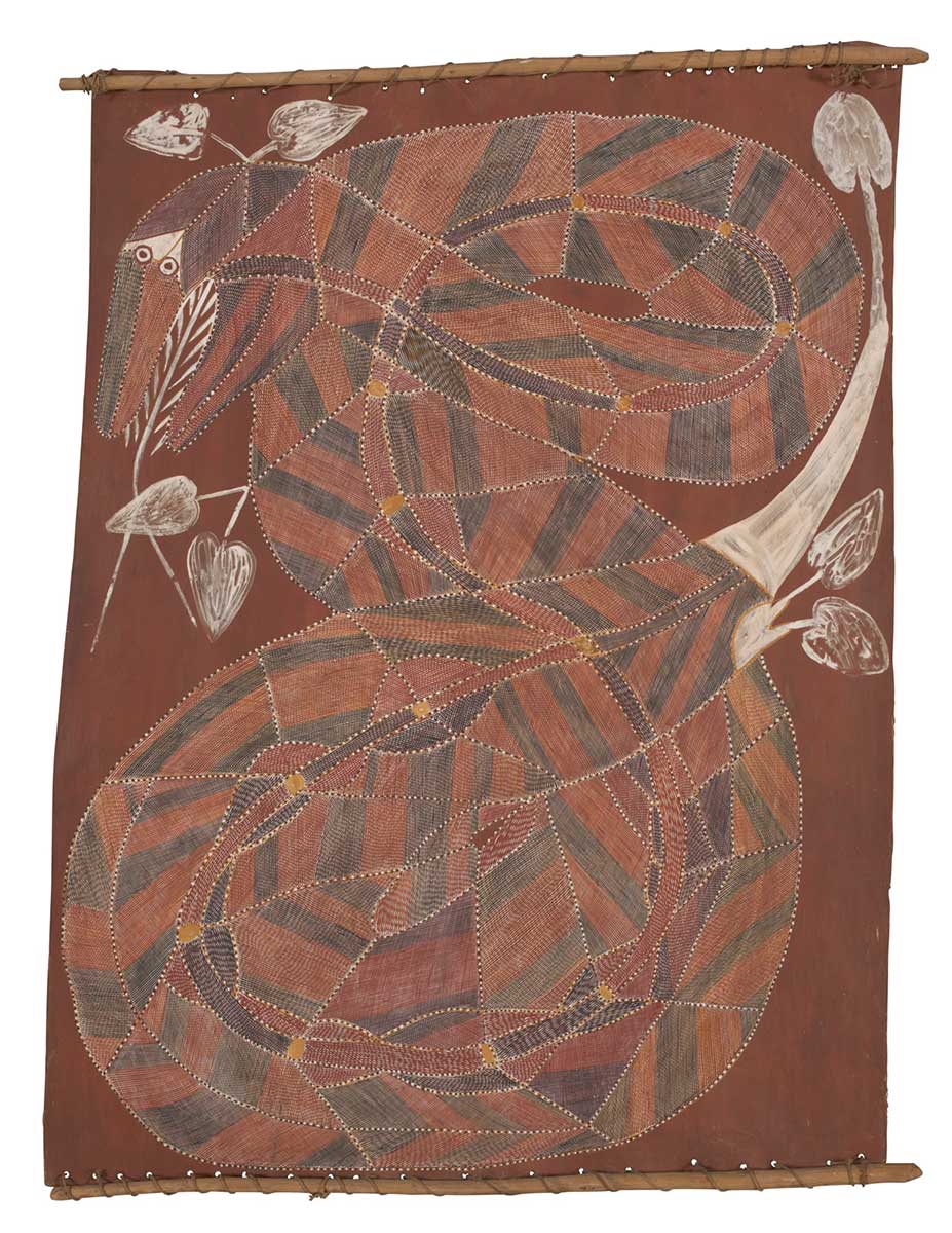 A bark painting worked with ochres on bark and on wooden restrainers. It depicts a coiled snake with its head in the top left hand corner.The snake is painted in brown, black and red crosshatching. In the upper section there are white leaves set against a red background. - click to view larger image