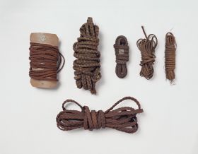 Plaited bands of varying thickness made of coconut fibres, and other plants. Some wrapped around old playing cards.