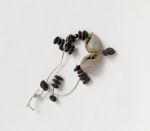 Necklace made of small brown oval seeds and white snail shells.