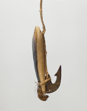 Large fishhook, with wood shank backed with mother-of-pearl and tied together. A barbed tortoiseshell hook also attached to the end.