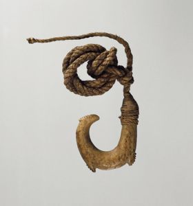 Small double barbed fishhook made of bone with a serrated outer edge and twisted cord.