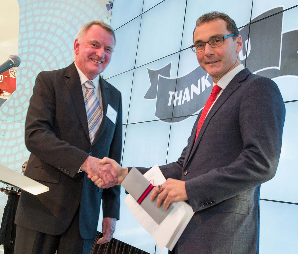 Michael Parker handing a cheque to Mathew Trinca.