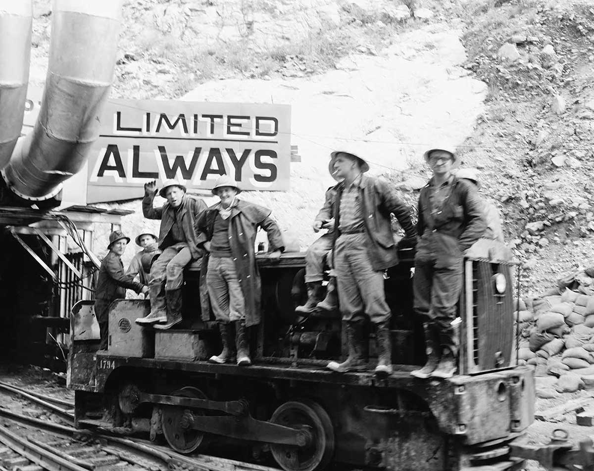 Photo of men riding rail truck entering or exit a tunnel at the Snowy Hydro.