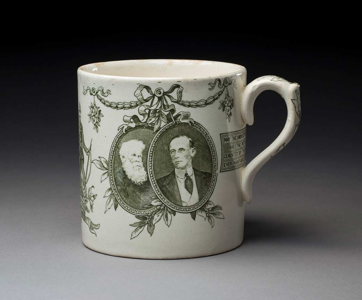 Souvenir china mug featuring vignettes of two men on one side. - click to view larger image