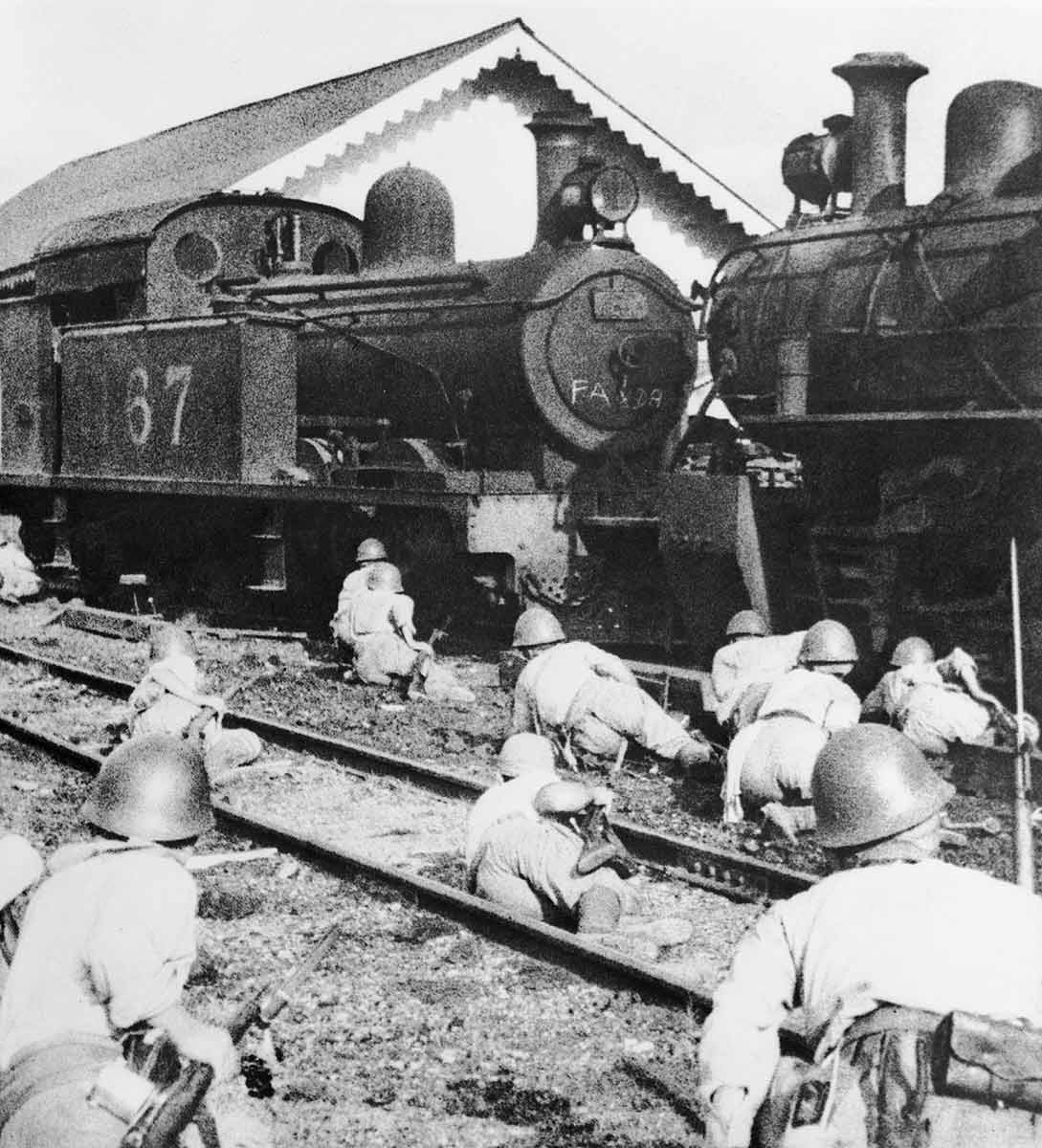 Soldiers crawling towards a steam engine. - click to view larger image