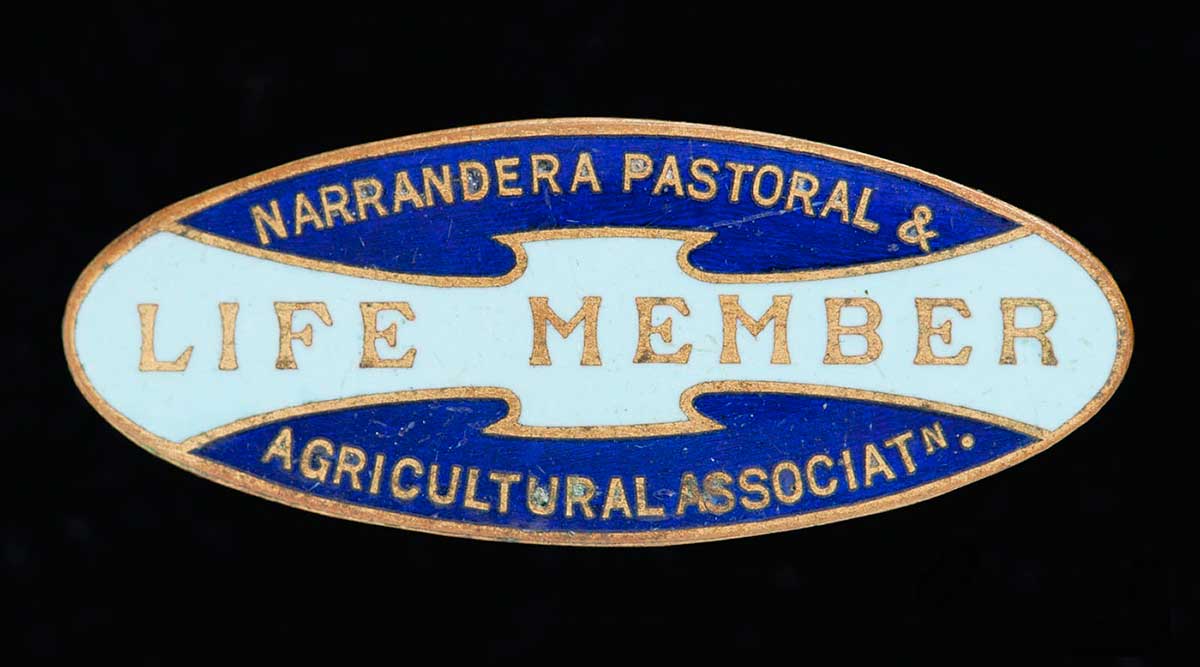 A blue and white badge with the words: 'Narrandera Pastoral & Agricultural Association Life Member'. - click to view larger image