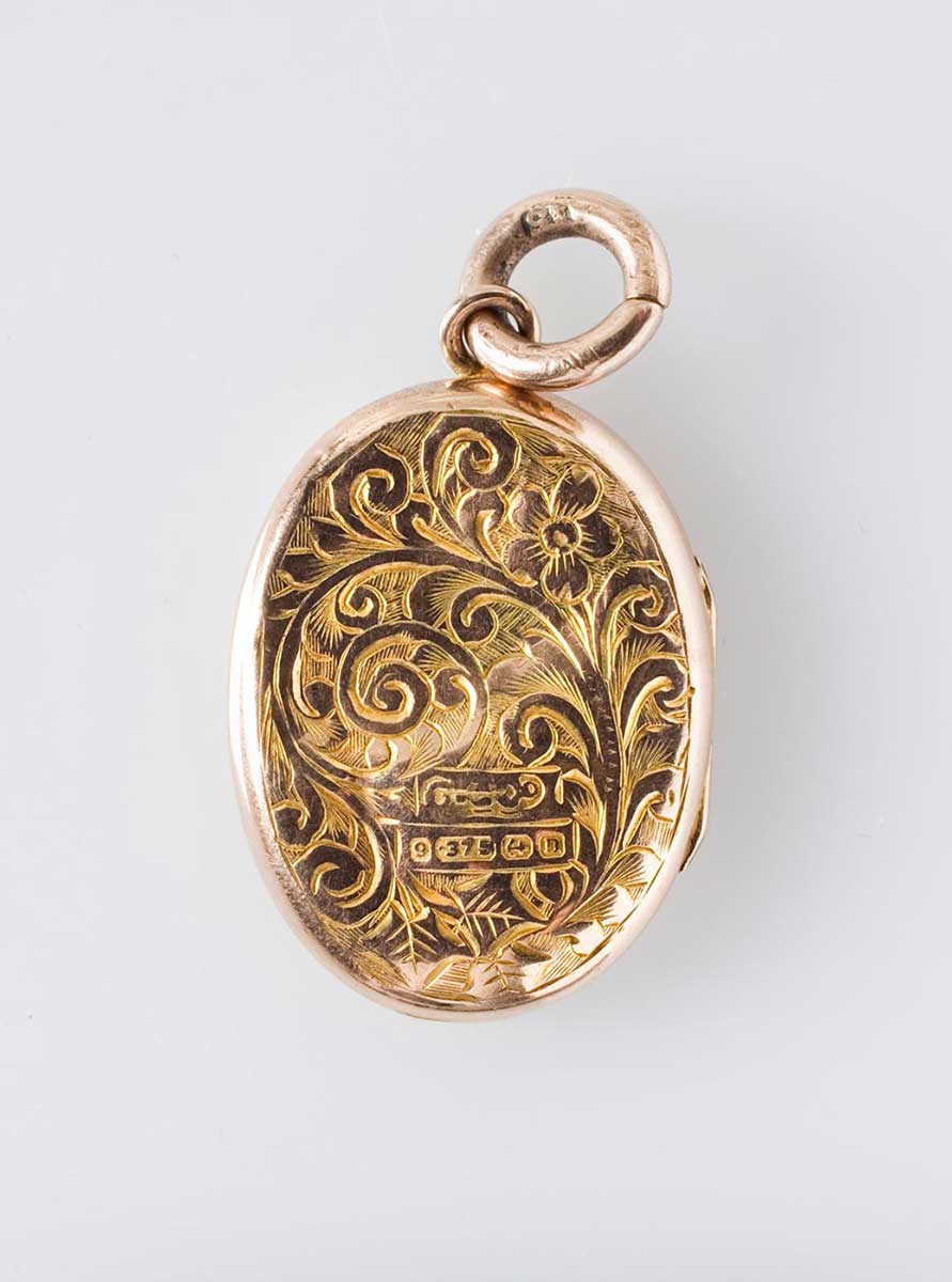 Image of the mourning locket, back view, featuring an intricate floral design. - click to view larger image