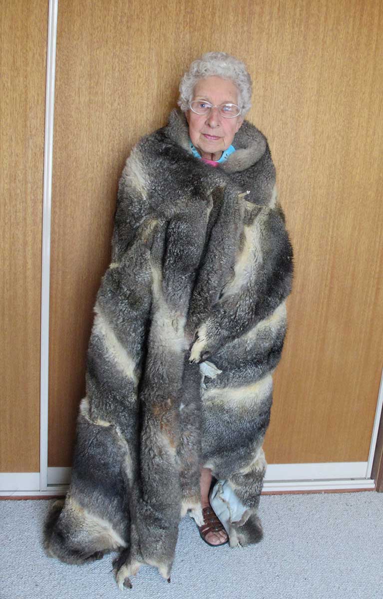 An image of an elderly lady wearing a possum-skin cloak. - click to view larger image