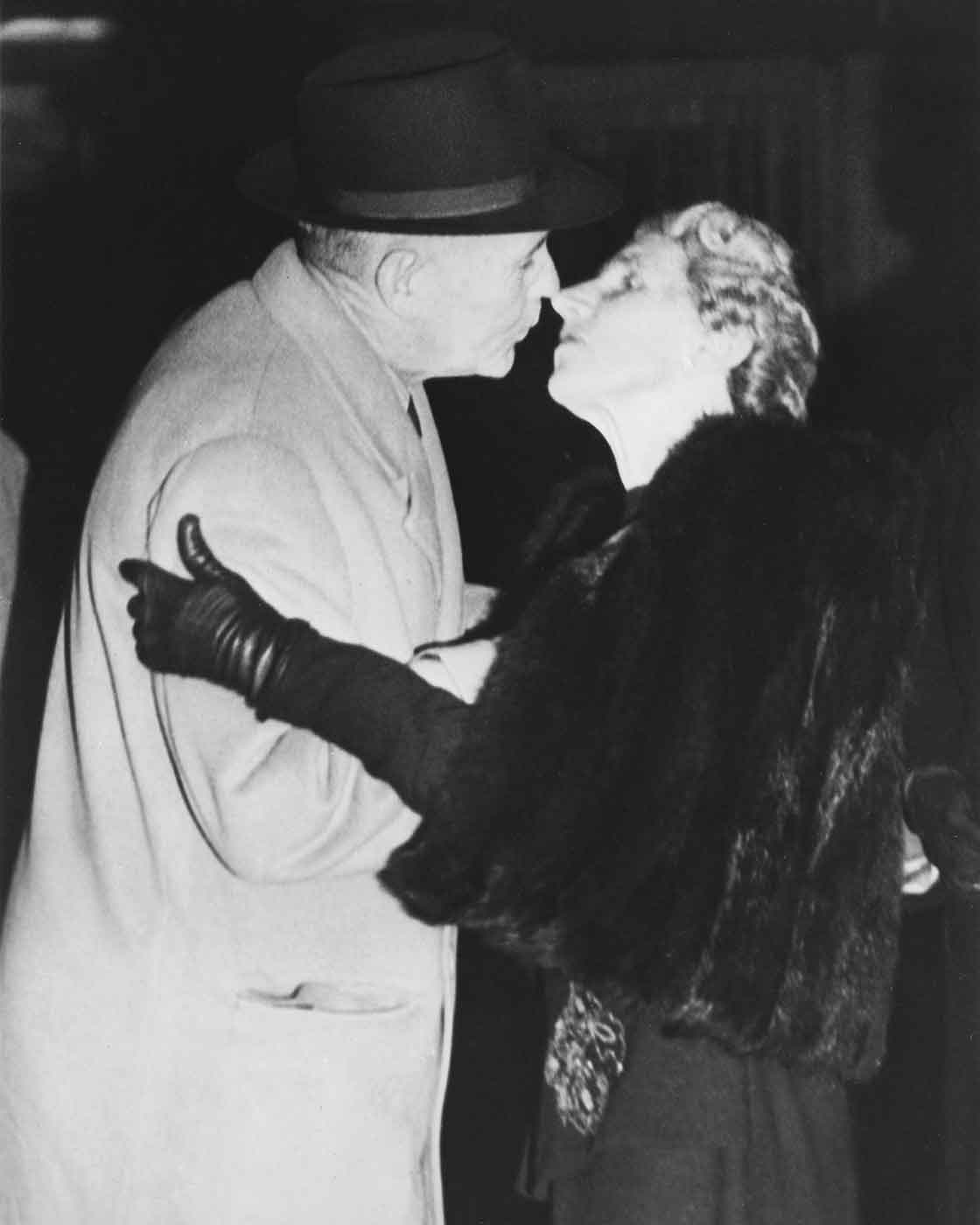 Black and white photo of a man kissing a woman. - click to view larger image