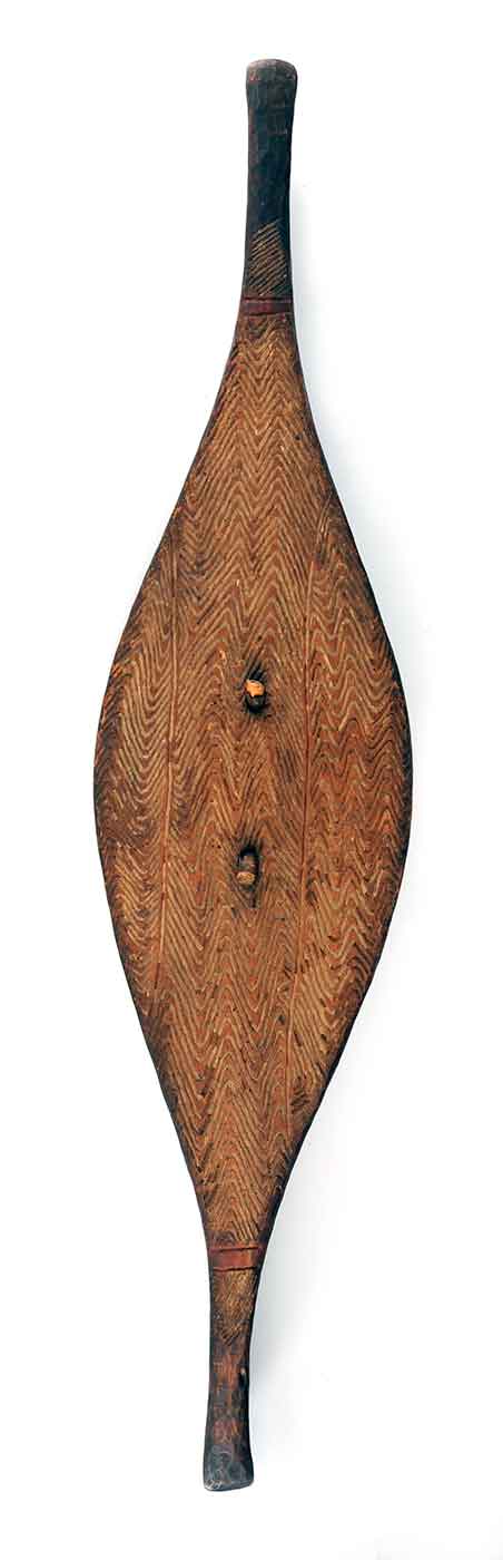 Front view of a long tear-drop shaped shield with tapered ends and wave design incised into surface. - click to view larger image