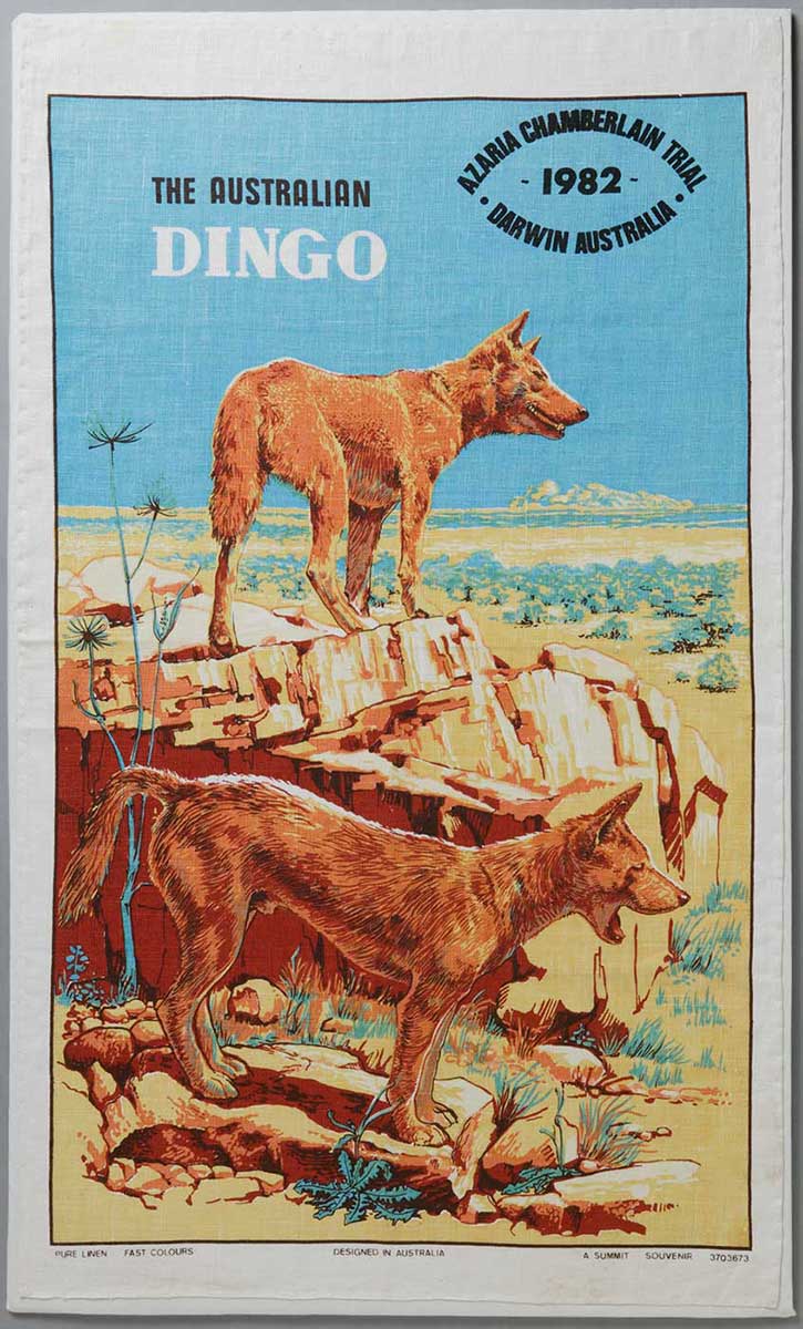 Tea towel featuring illustrations of two dingos in the AUstralian outback. There is a logo that reads: AZARIA CHAMBERLAIN TRIAL. 1982. DARWIN AUSTRALIA. - click to view larger image