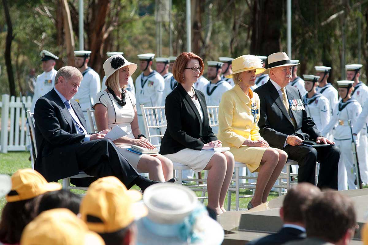 Katy Gallagher, Julia Gillard and Quentin Bryce attend an official ceremony with the navy in the background.