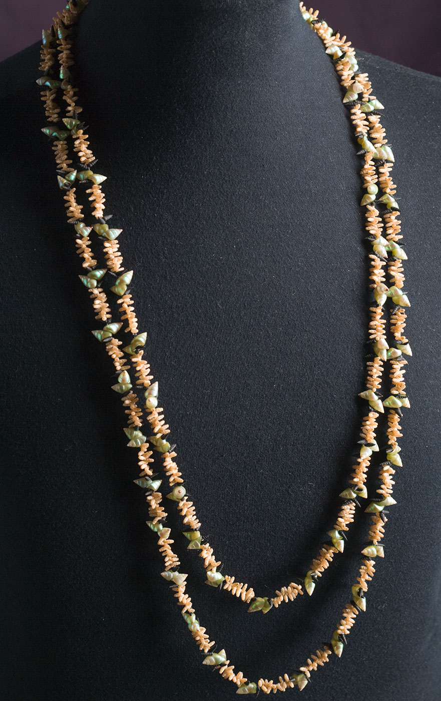 A necklace made from sea shells displayed on a dressmaker's dummy. - click to view larger image