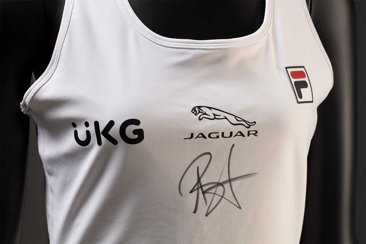 A singlet features a 'UKG' logo and 'JAGUAR' logo, as well as a handwritten signature in black ink. - click to view larger image