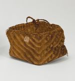 Basket made of pandanus leaves of yellowish and brown strips with a torn handle of plaited coconut fibre.