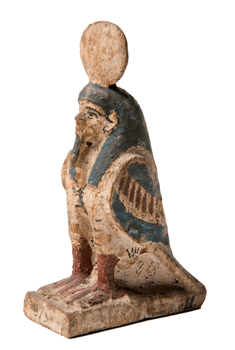 A colourfully painted carved bird figure with a human head and a sun disc crowning its head.