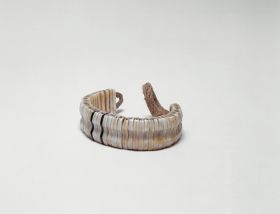 Bracelet made from ivory or dog teeth and turtleshell and strung together on a cord.