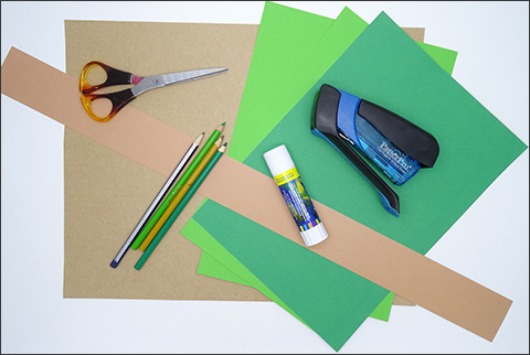 A small pile of green paper leaves with a white background.