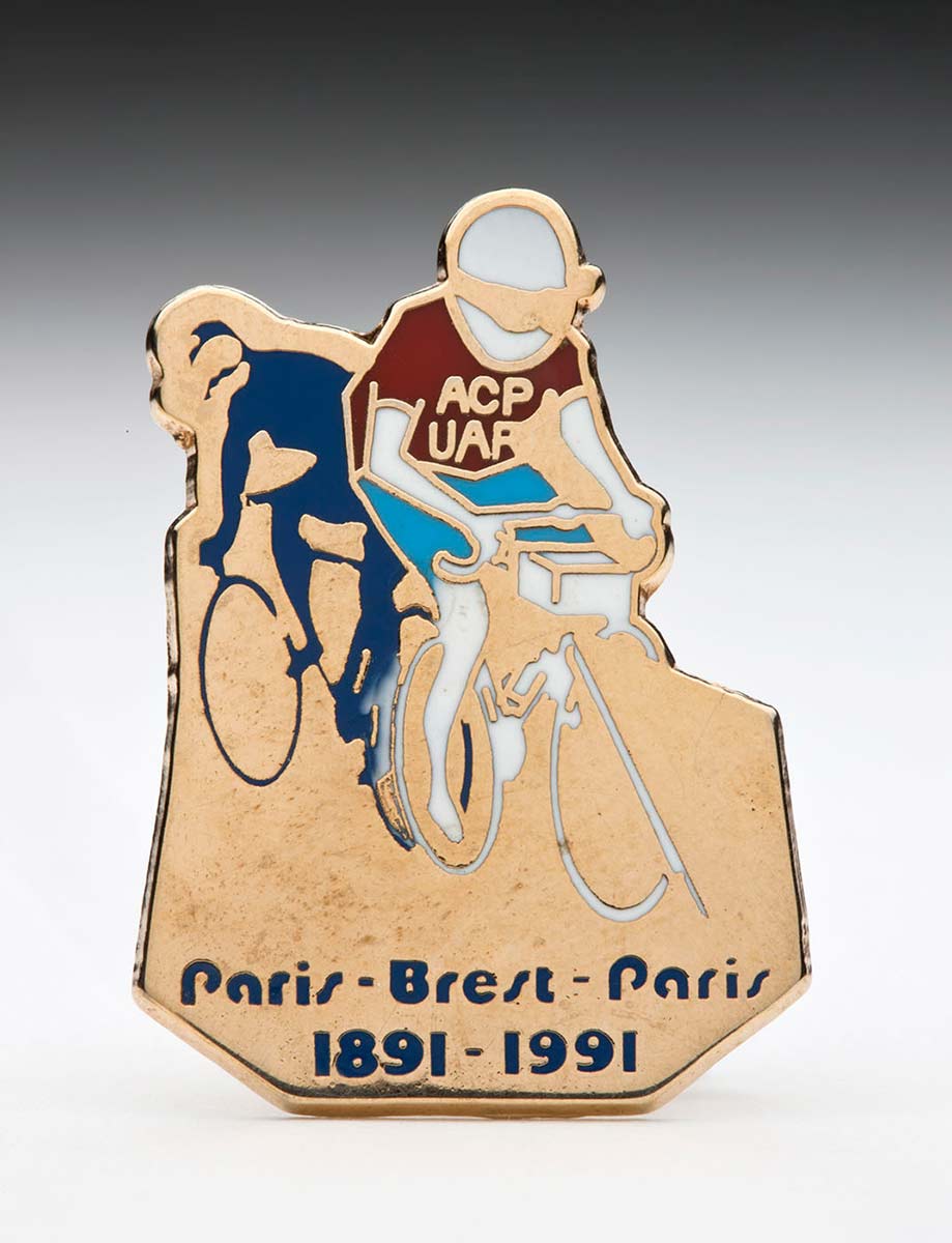 Gold badge with two cyclists at top and Paris-Brest_Paris 1891-1991 at bottom - click to view larger image