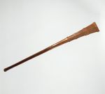 Club made of brown wood that is slightly rhomboid shaped at one end and ornamented with dots and diagonal, zigzag, and horizontal lines. Both ends separated by eight bulged rings.